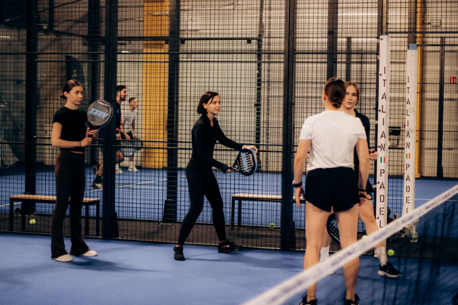 Vier padelspelers samen op een indoor padelbaan
